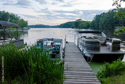 Looking out onto a Wisconsin northwoods lake as the last rays of sunlight begin to fade.  Many pontoon boats have returned from fishing for the evening.