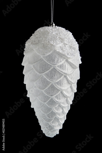 White Christmas tree toy in the shape of a fir cone isolated on a black background