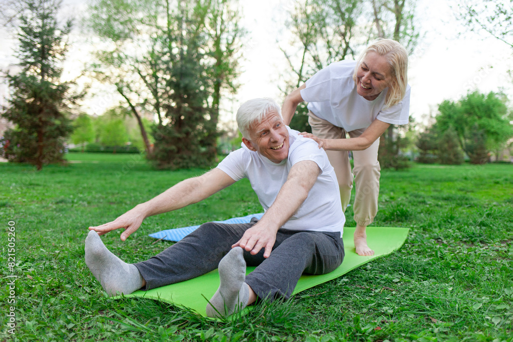 elderly senior couple man and woman doing yoga and meditating in a park in open space, gray-haired grandparents doing sports and active lifestyle in nature elderly senior couple man and woman doing yoga and meditating in a park in open space, gray-haired grandparents doing sports and active lifestyle in nature