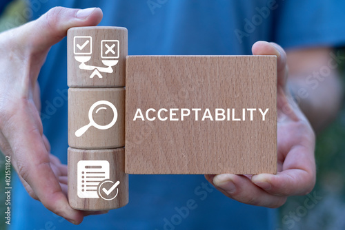 Man holding wooden blocks with icons sees word: ACCEPTABILITY. Acceptability business web concept. Accepted, right, correct.