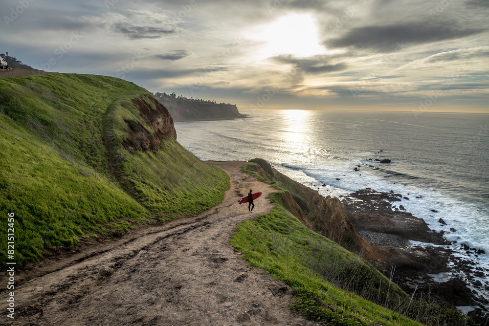 Naklejka premium Surfer's Journey Down the Rugged Bluff Trail