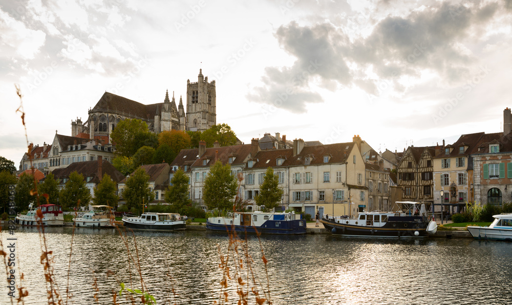 View of city landscape of Auxerre with Cathedral of Saint-Etienne on River Yonne on cloudy autumn day, Burgundy, France