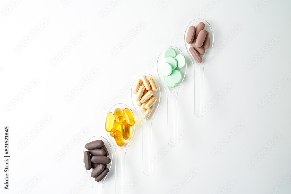 Fototapeta premium Various vitamin and mineral pills in transparent spoon food supplement health product