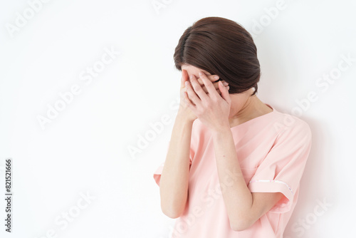 体調不良の女性看護士（白背景・白バック） photo