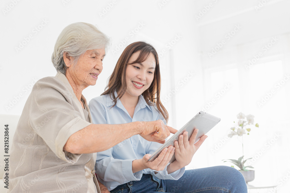 Asian female and mother search information with tablet computer, they feeling happy and smile, old people learning to use laptop, mother's day and happiness family time, technology and social network Asian female and mother search information with tablet computer, they feeling happy and smile, old people learning to use laptop, mother's day and happiness family time, technology and social network