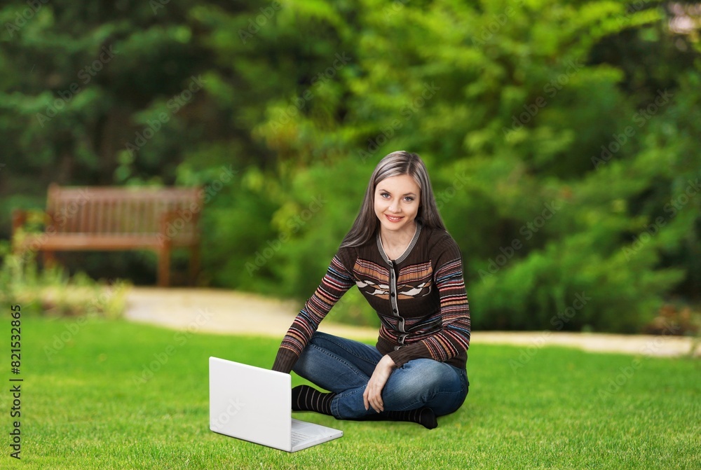 Young happy girl student with laptop computer outdoors.