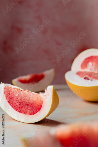 pink sliced pomelo on a pink background