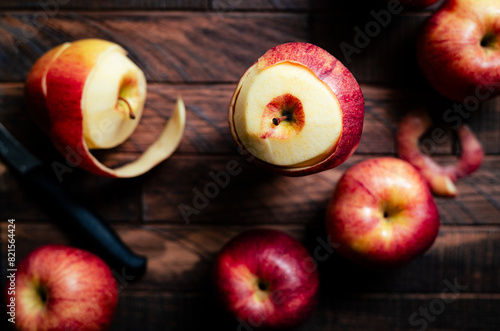 peeling red apples on a wooden surface photo