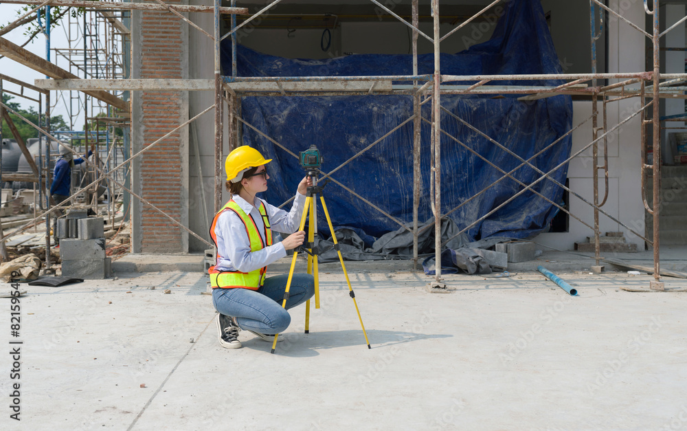 A construction worker is using a laser gauge to capture the setting of masonry, plastering and wall work at a building site. A construction worker is using a laser gauge to capture the setting of masonry, plastering and wall work at a building site.