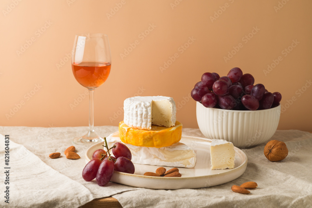 Cheese, grapes, nuts and wine glass on table Cheese, grapes, nuts and wine glass on table