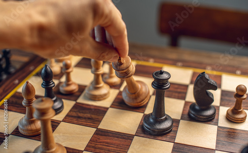 A wooden chessboard with pieces. Checkmate and the fall of the king by white