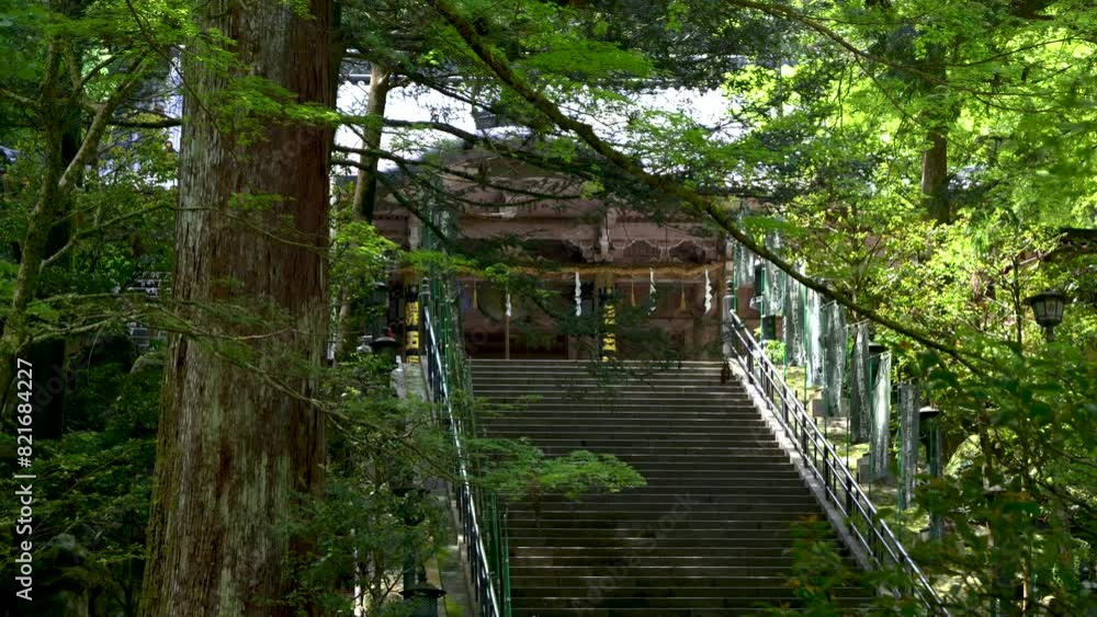 High stone steps at beautiful temple building inside lush Japanese green forest High stone steps at beautiful temple building inside lush Japanese green forest