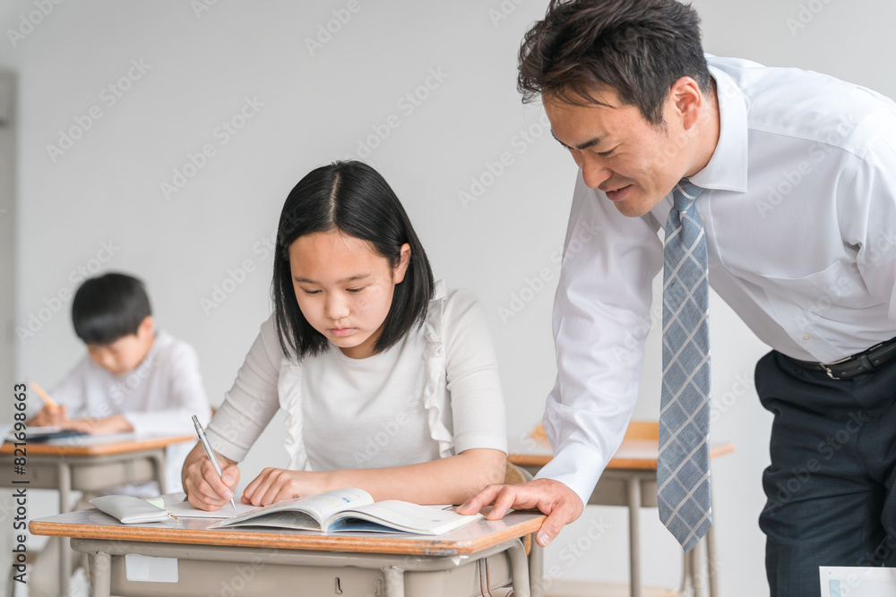 教科書を見ながら教える男性教師・塾講師・先生と質問する笑顔の小学生・中学生の生徒(女の子)
教科書を見ながら教える男性教師・塾講師・先生と質問する笑顔の小学生・中学生の生徒(女の子)