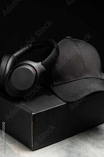 Baseball cap with black headphones on dark background