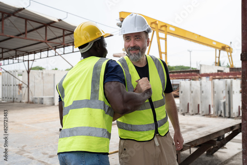 Portrait African American engineer man hand shake with caucasian engineer man at precast cement outdoor factory	 photo