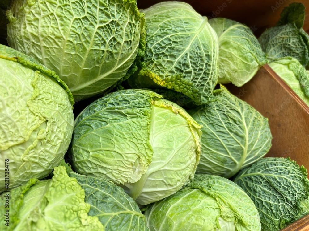 Fototapeta premium Close-up of green cabbages in a wooden box at NYC market