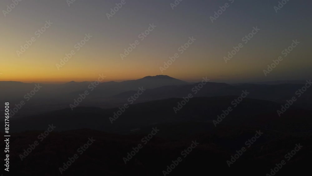 Aerial of mountain silhouettes in beautiful valley at dusk Aerial of mountain silhouettes in beautiful valley at dusk