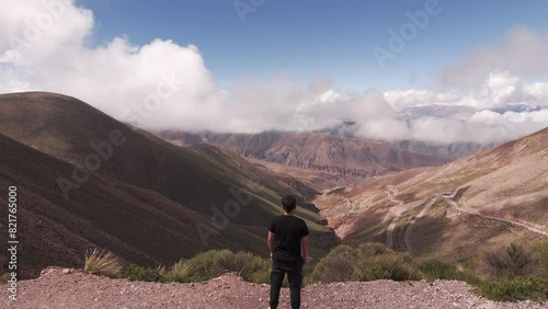 Aerial view of man standing on hill admiring the landscape of Route 52, Lipan Slope. Jujuy, Argentina. 4k drone. photo