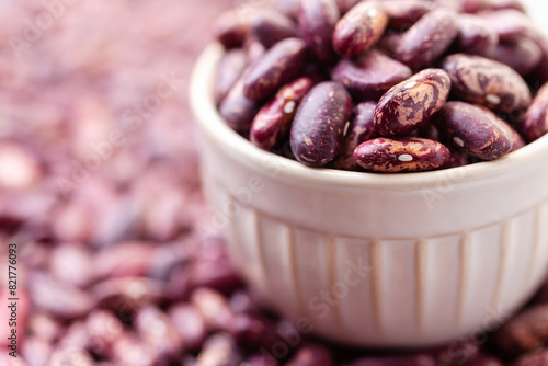 Uncooked variegated kidney bean seeds in bowl. Red and white dry beans