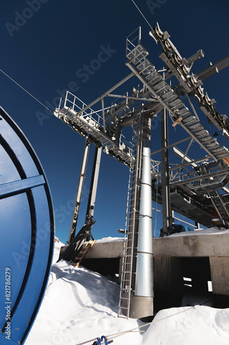 A cable car station high in the mountains under construction. Snowy mountain landscape and construction of a metal structure for a cable car