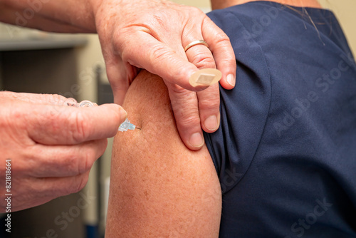 woman receiving vaccination injection from nurse, needle hypodermic immunisation, Australian general practice, GP doctor medical clinic, influenza covid infection, prevention health care