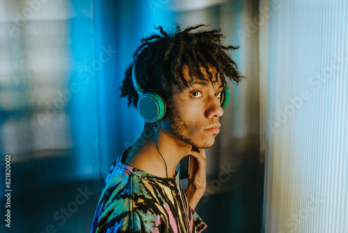 Thoughtful man listening music through wired headphones photo