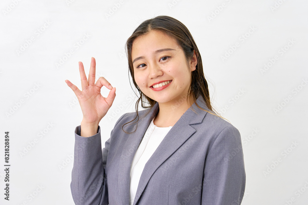 OKサインをする若いビジネスウーマン　白背景