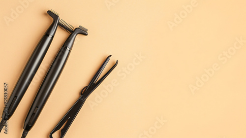 Curling iron and hair straightener on beige background photo