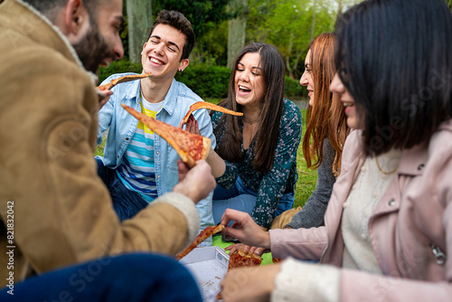 Group of Friends Eating Pizza Outdoors - Joyful and Social Moment