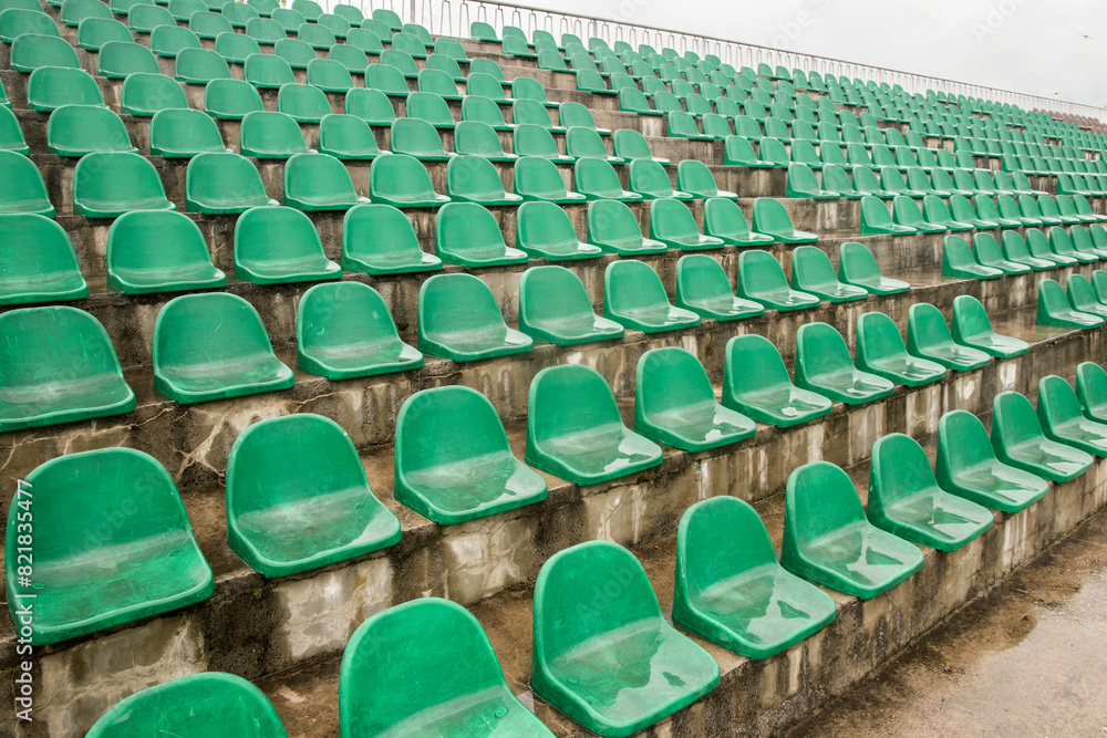 Fototapeta premium Green plastic stadium worn out chair seats in rows