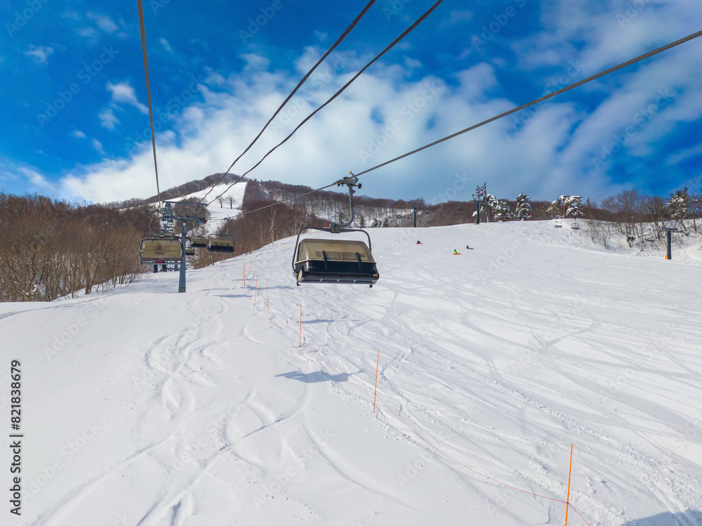Snow slopes viewed from a chairlift on a sunny day (Madarao Kogen, Nagano, Japan) Snow slopes viewed from a chairlift on a sunny day (Madarao Kogen, Nagano, Japan)