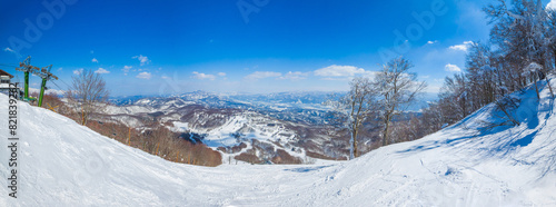 Panorama view of snow resort from the top of a steep slope a sunny day (Madarao Kogen, Nagano, Japan) photo