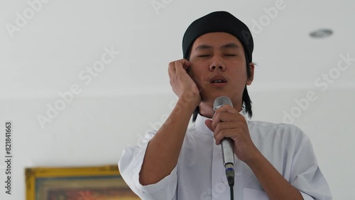 Young Asian Muslim Man Doing Adhan In Mosque photo