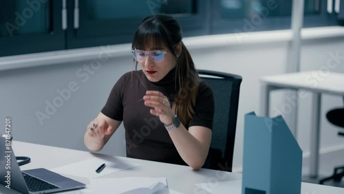 Close up of a young beautiful woman with dark hair working on papers, being tired at work in office, having a migraine in slow motion. photo