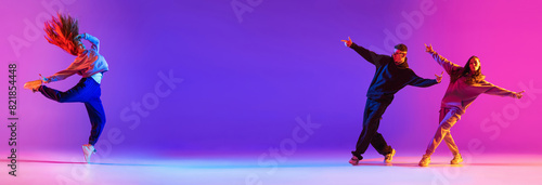Banner. Young active couple  boys and girls dancing contemp  hip hop against gradient studio background in neon. Concept of contemporary dance style  youth  hobby  action and motion. Ad