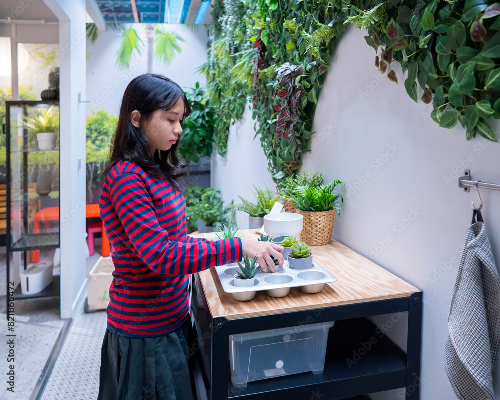 Indonesian teenage girl arranging and planting mini fresh plant in the backyard at home. Indonesian teenage girl arranging and planting mini fresh plant in the backyard at home.