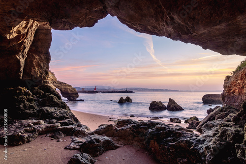 View of Lagos marina entrance at sunrise from the rocky coastline at Praia dos Estudantes Beach, Lagos, Algarve, Portugal	