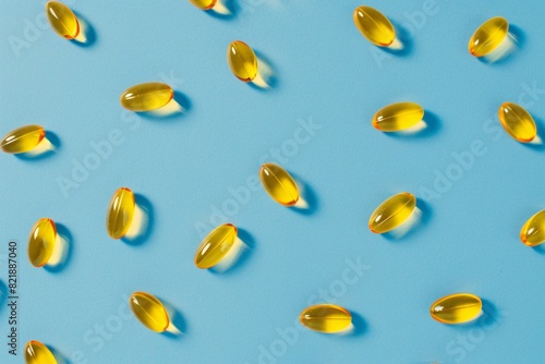 a group of yellow pills on a blue surface