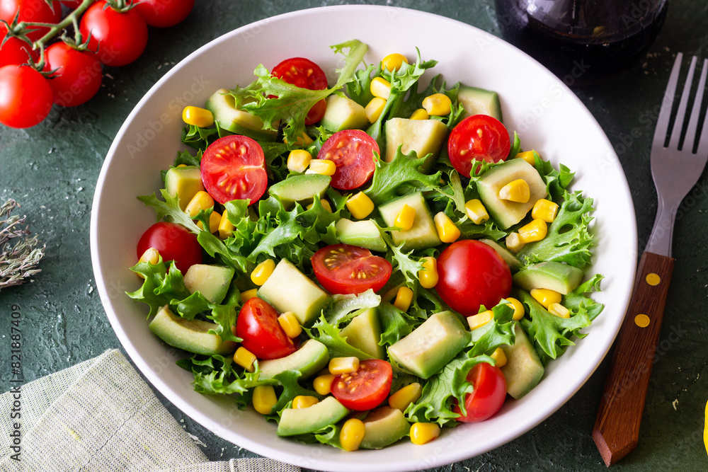 Salad with avocado, tomatoes and corn. Healthy eating. Vegetarian food.