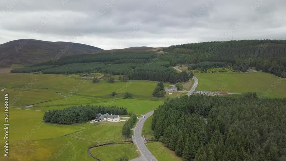 Aerial view of peaceful village with winding road and lush fields, Cock Bridge, Aberdeenshire, Scotland. Aerial view of peaceful village with winding road and lush fields, Cock Bridge, Aberdeenshire, Scotland.