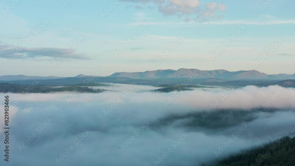 Aerial view of Lake Windermere surrounded by misty mountains and serene clouds, Lake District, England. Aerial view of Lake Windermere surrounded by misty mountains and serene clouds, Lake District, England.