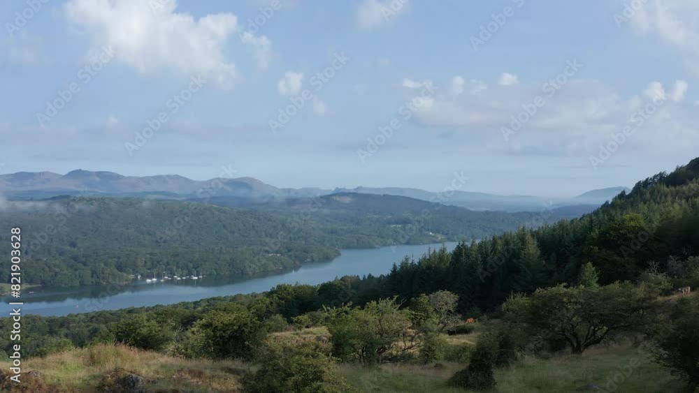Aerial view of Lake Windermere surrounded by mountains and lush forest, Lake District, United Kingdom. Aerial view of Lake Windermere surrounded by mountains and lush forest, Lake District, United Kingdom.