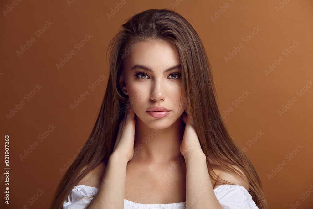 Attractive lady with loose hair posing for camera on brown Attractive lady with loose hair posing for camera on brown