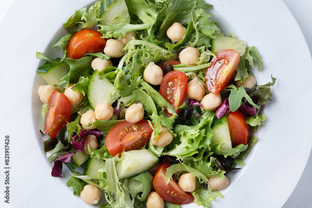 Healthy chickpea salad with tomato,lettuce and cucumber isolated on white background. Close up Healthy chickpea salad with tomato,lettuce and cucumber isolated on white background. Close up