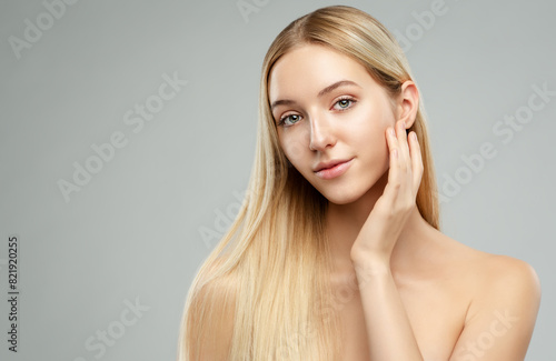 Face Skin Care. Beauty Girl apply Facial Cream over Gary. Beautiful Blond Hair Model with Hand on Cheek. Spa Massage. Skin Treatment. Dermal Filler Cosmetology