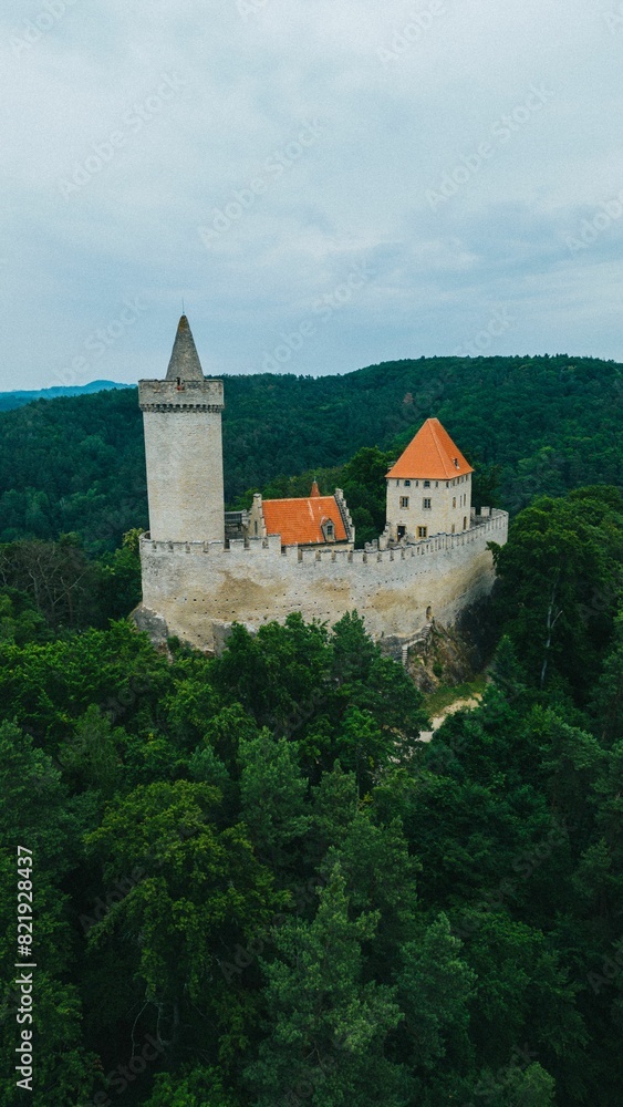 Drone view of the Kokorin Hrad castle in the middle of a forest in the country of Czech Republic. Drone view of the Kokorin Hrad castle in the middle of a forest in the country of Czech Republic.