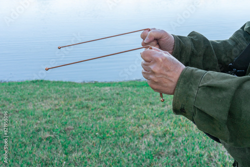 Fotografie Person using dowsing rods to discover the source of water