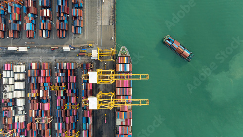 top down view from drone, crane lift container into the transport ship in commercial port, shipping business and industry service of cargo logistic import and export international 