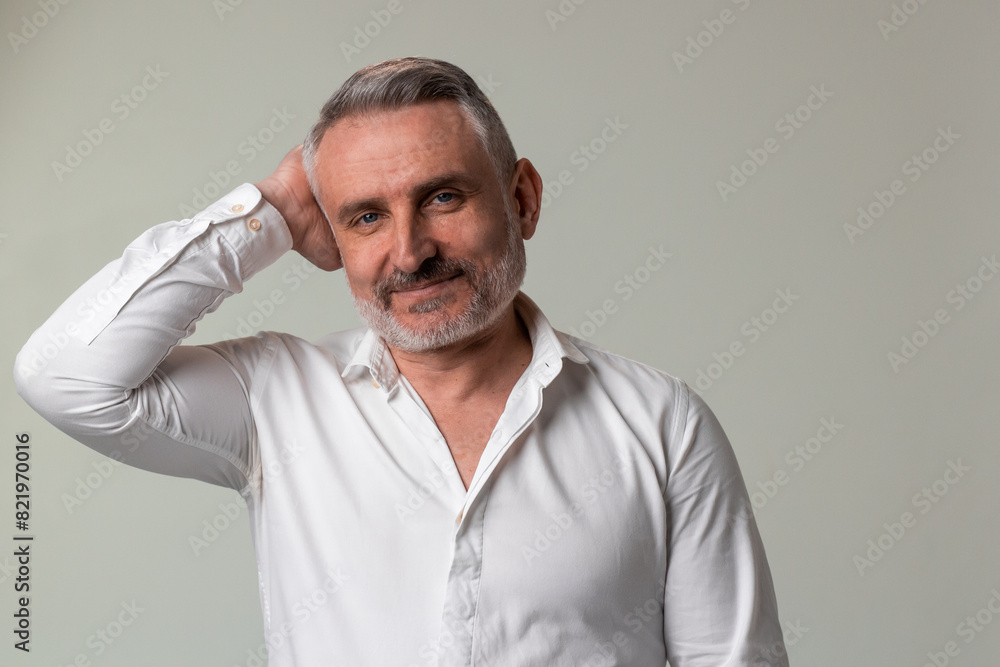 Bearded man in white dress shirt makes a gesture with hand on forehead, His beard is neatly trimmed and his sleeves are rolled up Bearded man in white dress shirt makes a gesture with hand on forehead, His beard is neatly trimmed and his sleeves are rolled up