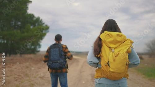 Wallpaper Mural man and woman traveling. active tourism and travel around the world concept. two tourists, man and woman traveling with backpacks on their backs, walking along a road in the forest lifestyle Torontodigital.ca